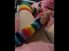 Femboy débil con uniforme de colegiala rosa y guantes y medias de arcoíris se corre