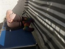 Sissy enjaulada juega con su consolador en un balcón público