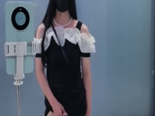 Ladyboy china con falda ajustada negra se corre en la puerta del baño público